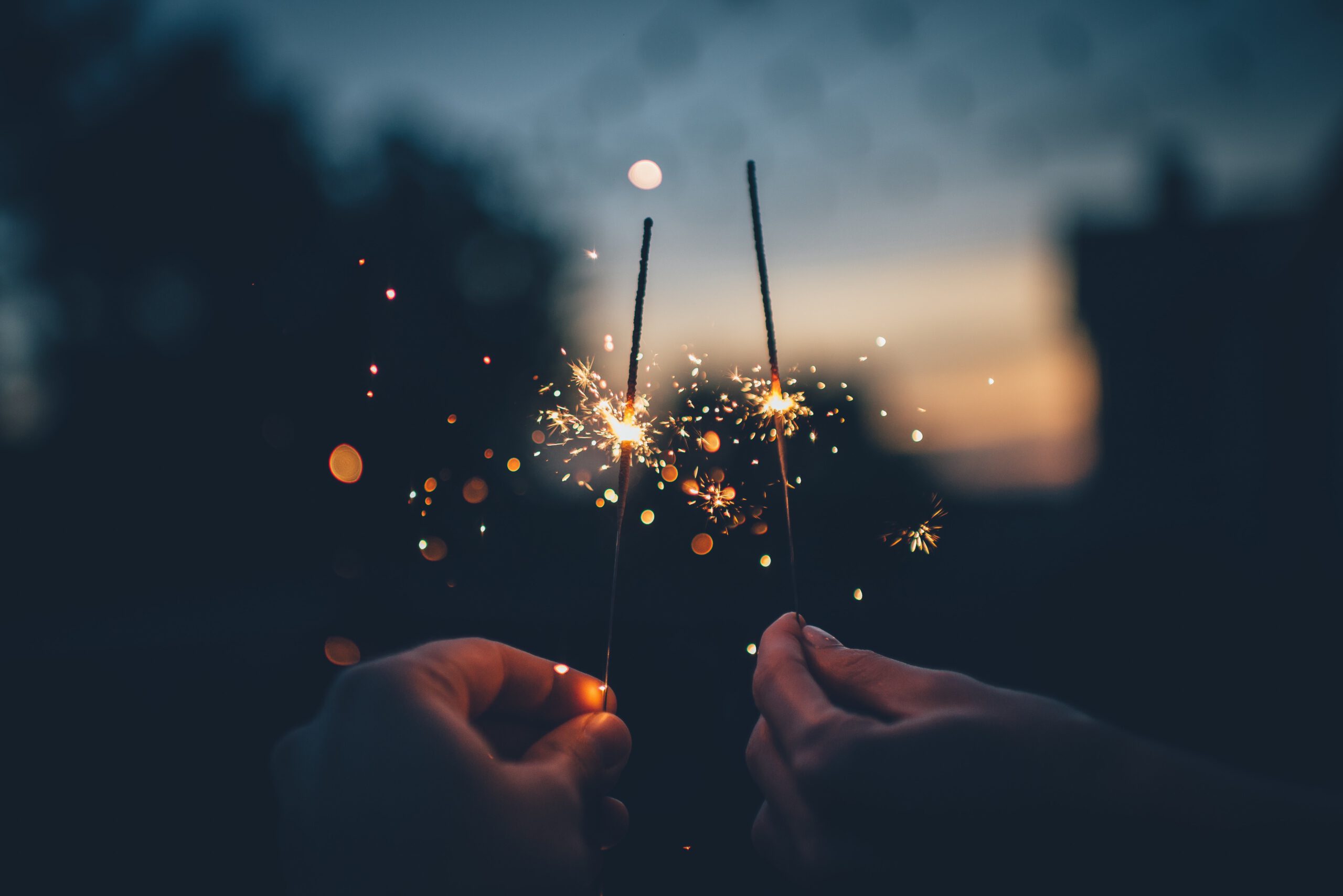 a picture of two hands holding sparklers